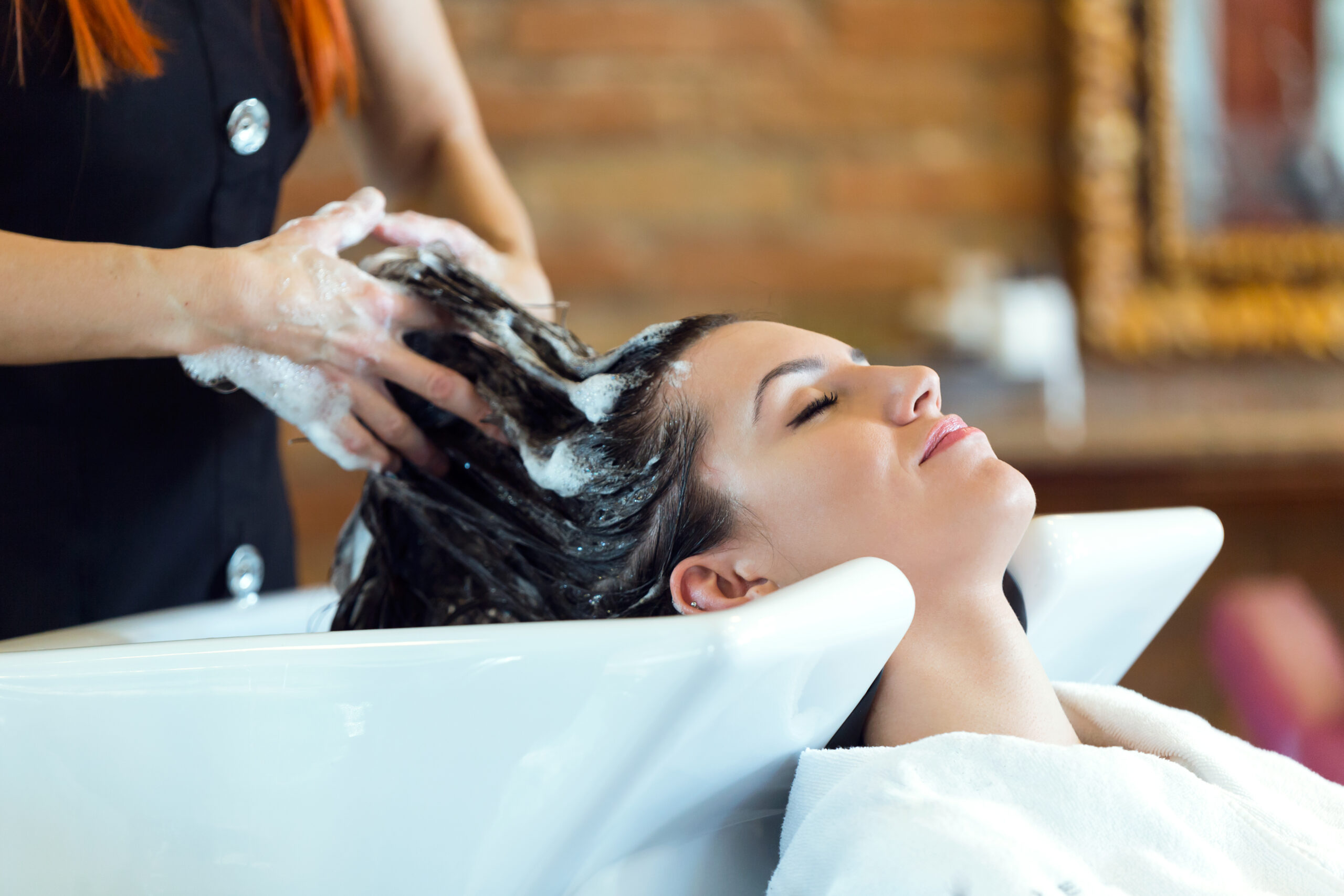 Portrait of beautiful young woman washes hair in a beauty salon.